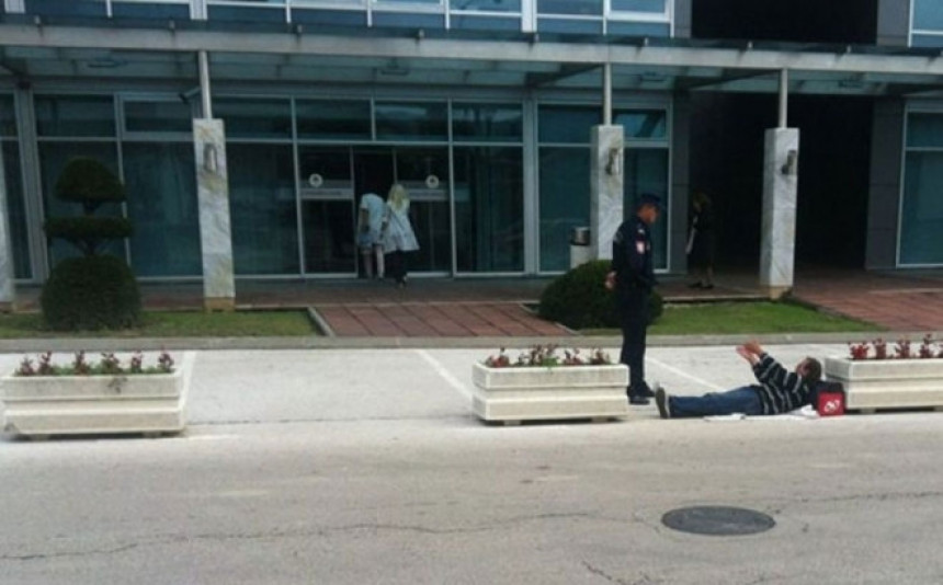 Muškarac legao ispred ulaza u zgradu Vlade 