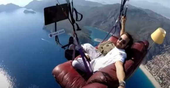 Neobičan paraglajding: Leteo sa kaučom i TV-om iznad mora! (VIDEO)